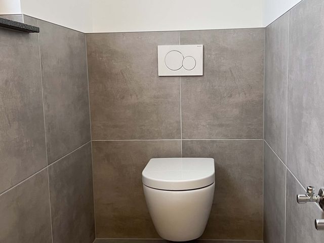 Wandhängendes WC vor großformatigen Fliesen